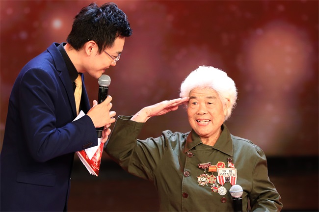 3 自治区职业病防治研究院退休职工、“天津医生”杨兴蓉在访谈结束后敬军礼，观众报以雷鸣般掌声。.JPG